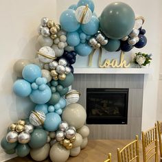 balloons are arranged in the shape of an arch on a table with gold and blue chairs