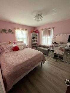 a bedroom decorated in pink and silver with lots of accessories on the bed, along with other furniture