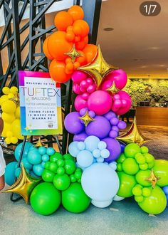 there are many balloons on the ground in front of a sign that says tuftex