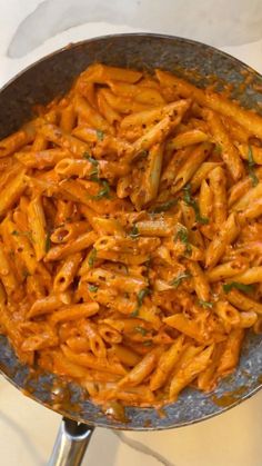 a pan filled with pasta and sauce on top of a stove