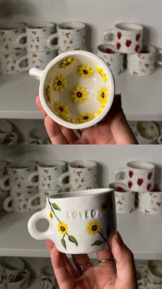 two mugs with yellow flowers painted on them, one is holding the other in its hand