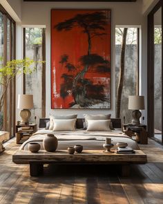 a large painting hangs above a bed in a bedroom with wood flooring and walls