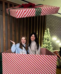 two women standing in front of christmas presents