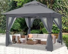 a gray gazebo sitting on top of a patio next to a table and chairs