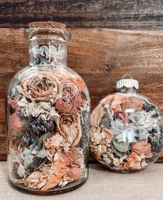 two glass vases with dried flowers in them