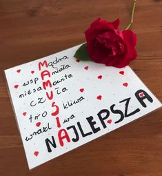 a red rose sitting on top of a piece of paper that says najepsza