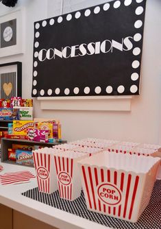 popcorn buckets are lined up on a counter in front of a sign that says concession