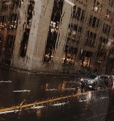 a rainy city street with buildings and cars