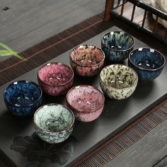 several bowls are sitting on a table with their lids open