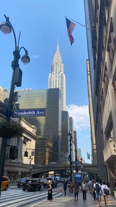 people are walking down the street in front of tall buildings