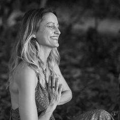 a black and white photo of a woman sitting on the ground with her eyes closed