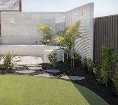 a white bench sitting on top of a lush green field next to a wooden fence