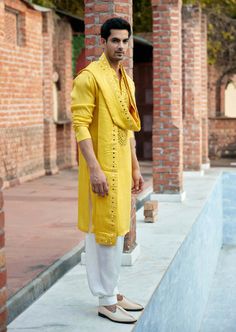 a man in a yellow outfit standing by a pool