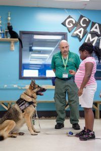 two people and a dog are standing in front of a game room with blue walls