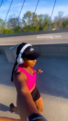 a woman in pink shirt and headphones on skateboard