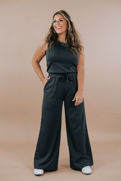 Introducing the Wide Leg Drawstring Jumpsuit in dark Charcoal, a sleek and versatile piece that effortlessly combines style and comfort. Crafted with soft and flowy fabric, this jumpsuit offers both elegance and ease of movement. Pair with a denim jacket for a laid-back look. Wide leg jumpsuit Drawstring jumpsuit Athleisure material Comfy Functional pockets Elastic waist band Adjustable tie Button closure in the back 49%polyester, 45% rayon, 6% spandex Imported MEASUREMENTS:S: INSEAM: 28”M: INSEAM: 28”L: INSEAM: 28 1/2” Model Specs: Karli is wearing a size small in the photo. How will this item fit you? Check out our MODEL SPECS (Typical Sizing - Karli: S-Size 5/26 - 5ft 2in, Emily: S-Size 3/25 - 5ft 5in, Syd: L/XL- Size 15/ - 5ft 8in)Need help with sizing? No problem! Join our VIP group o Versatile Wide Leg Jumpsuit Or Romper, Wide Leg Loungewear Jumpsuit, Solid Color Wide Leg Jumpsuits And Rompers For Loungewear, Solid Color Wide Leg Jumpsuits For Loungewear, Wide-leg Jumpsuits For Loungewear, Black Wide Leg Jumpsuits For Loungewear, Black Wide Leg Jumpsuits And Rompers For Loungewear, Black Lounging Jumpsuits And Rompers For Spring, Versatile Jumpsuits And Rompers For Loungewear