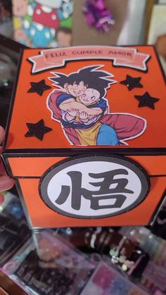 someone holding up a box with an image of gohan on it