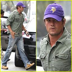 a man wearing a purple hat and green shirt is walking in front of a car