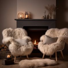 two chairs with fur on them in front of a fire place and candles around it