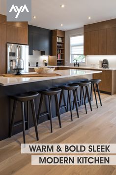 a kitchen with wooden floors and black counter tops next to an island in the middle