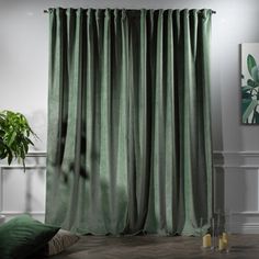 a living room scene with focus on the green curtains and floor to ceiling drapes