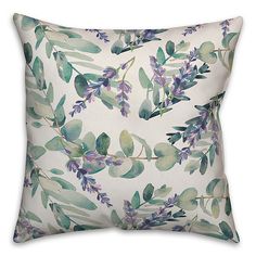 a white pillow with blue and green leaves on it