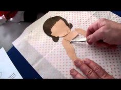 someone cutting out a paper cutout of a woman's face on a piece of paper