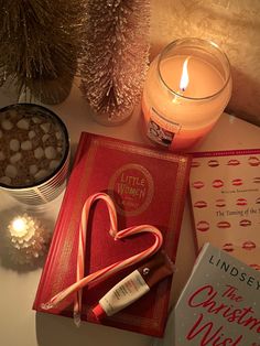 a candle, book and candy cane on a table