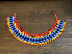 a multicolored crocheted necklace on a wooden surface