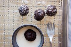 chocolate cookies and cream in a pan on a cooling rack next to a fork, spoon and cupcakes