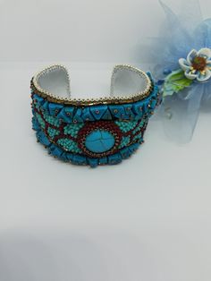 Beautiful and elegant bracelet in a slightly ethnic style, hand embroidered with a central turquoise cabochon and aulite gems. It is difficult and slow work, it took many hours of work from planning to realization of the final project. Each bead is individually hand sewn to create the final design. Inside the bracelet is covered in natural leather which gives a soft touch to the skin. This bracelet is comfortable to wear, goes perfectly with clothes of different colors. The colors used recall summer, the sea and the sun... The width of the bracelet is 4cm (1.6 inches). It has a brass plate inside that holds its shape and fits any wrist size. Wearing this bracelet will make you feel unique and special. Each piece is unique. If you would like a personalized bracelet in the colors of your cho Multicolor Embroidered Bangle Jewelry, Handwork Multicolor Bangle Jewelry, Artisan Turquoise Beaded Bangle Bracelets, Artisan Turquoise Beaded Bangle Bracelet, Unique Turquoise Beaded Bangle Bracelet, Multicolor Handmade Bracelet For A Gift, Multicolor Handwork Bracelets As Gift, Multicolor Handwork Bracelet For Gifts, Multicolor Handwork Bracelet As Gift