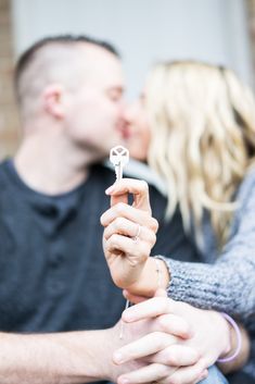 a man and woman kissing while holding an open key