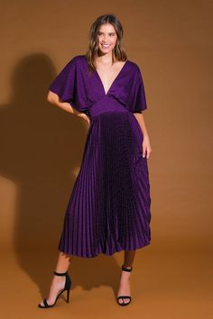 a woman in a purple dress posing for the camera