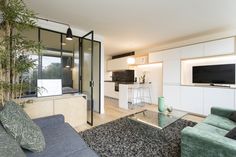 a living room filled with furniture and a flat screen tv on top of a wall