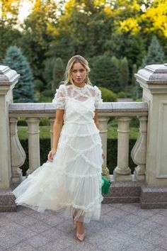 a woman wearing a white dress and heels