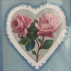 a painting of two pink roses in a heart shaped frame on a blue and white background