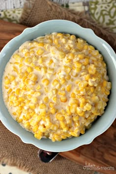 a bowl filled with corn on top of a wooden table