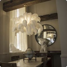 a dining room table with a globe on it and a mirror hanging from the ceiling