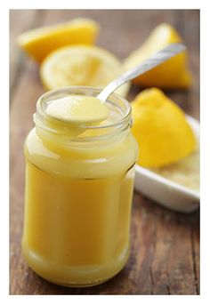 a jar filled with yellow liquid sitting on top of a wooden table