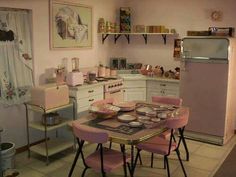 a kitchen with pink chairs and a table in front of an oven, refrigerator and microwave