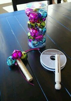 a glass filled with lots of colorful beads next to a canister on top of a wooden table