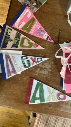 several pennants are laid out on a table with scissors and other crafting supplies