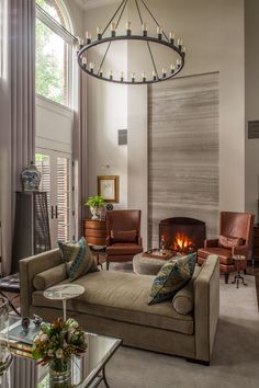 a living room filled with furniture and a fire place in the middle of it's wall