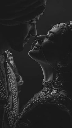 two people in black and white with one woman kissing the other's foreheads