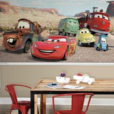 the cars are lined up on the wall next to the table