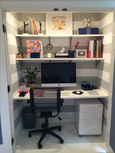 a computer desk sitting in the corner of a room next to a bookshelf