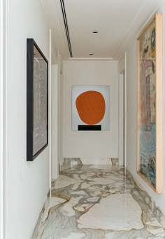 an empty hallway with paintings on the wall