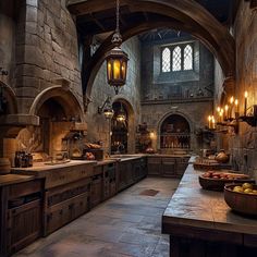 an old fashioned kitchen with lots of counter space and lights hanging from the ceiling above it