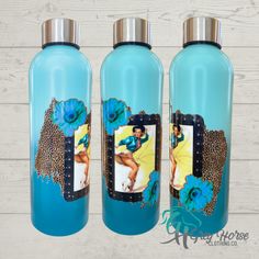 three blue water bottles with an image of a woman on the front and back, one is