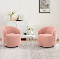 two pink chairs sitting next to each other on a rug in front of a white wall